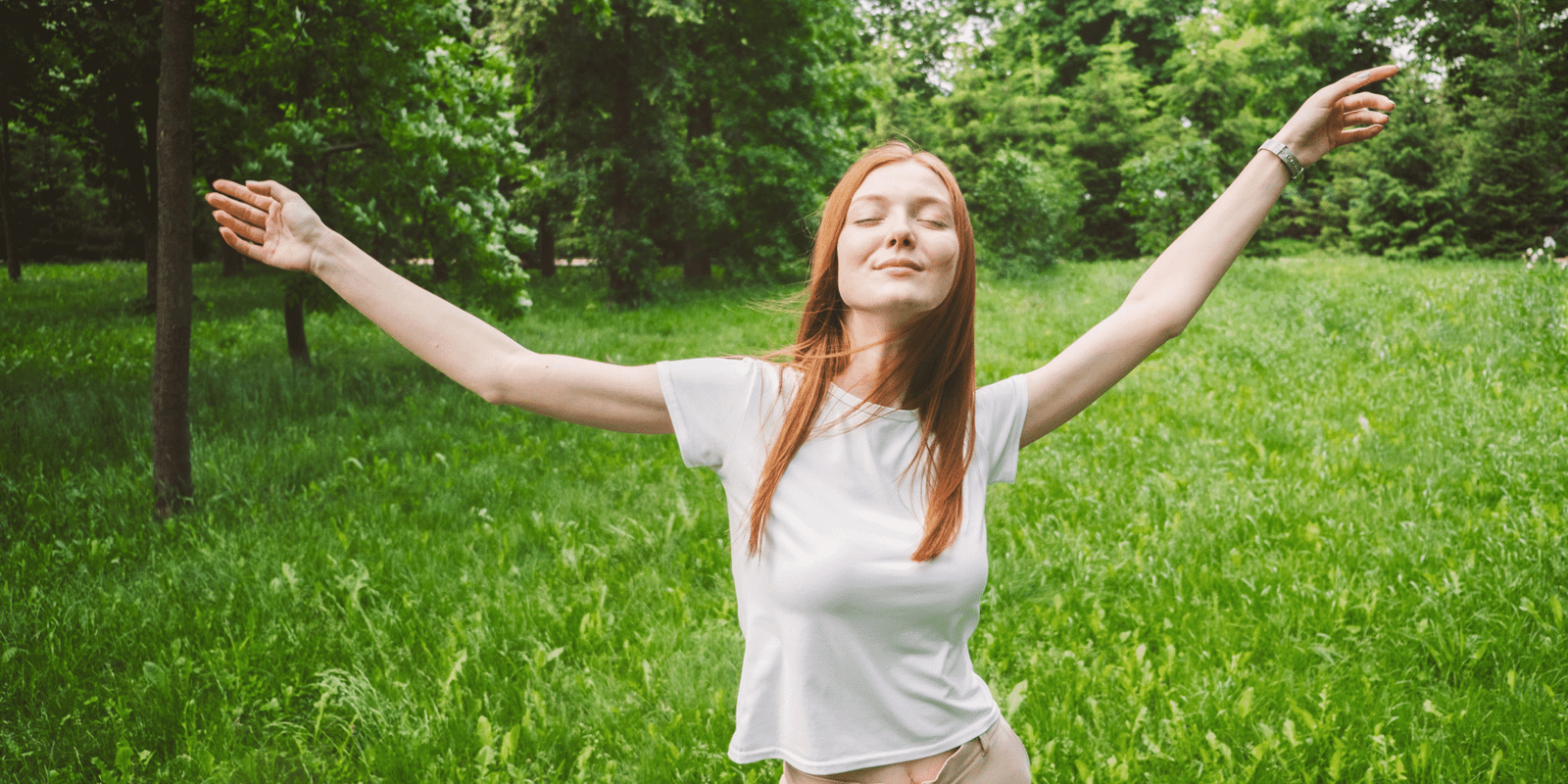 Woman embracing positivity and inner peace in a natural green outdoor setting